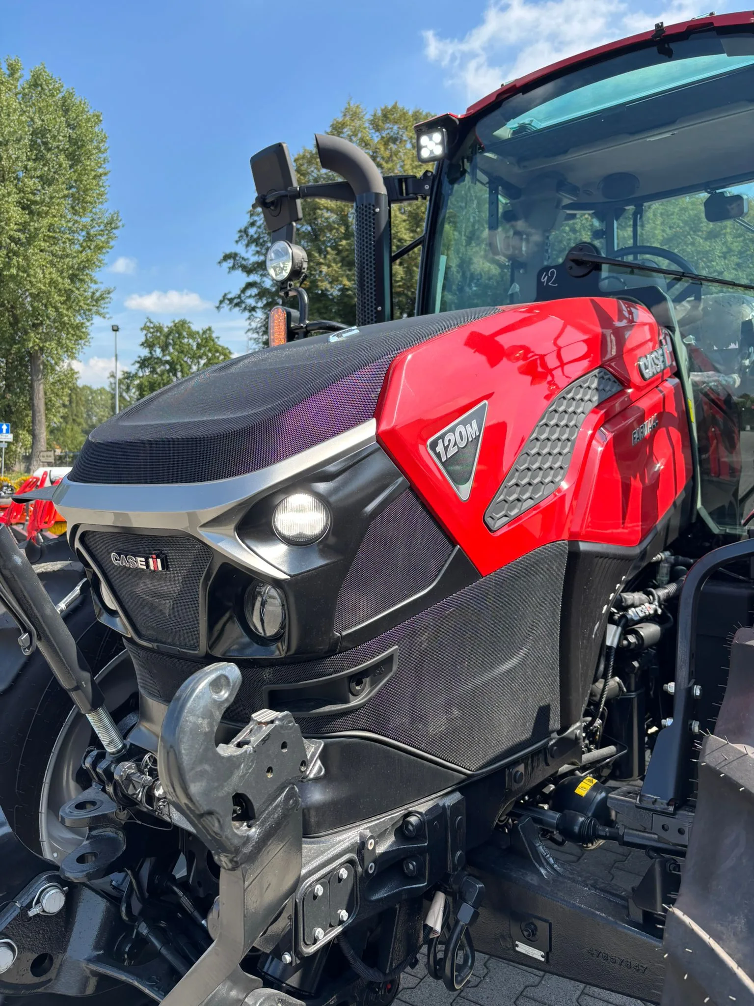 Maska i kabina ciągnika CASE IH FARMALL 120M widziane z przodu, oświetlenie LED