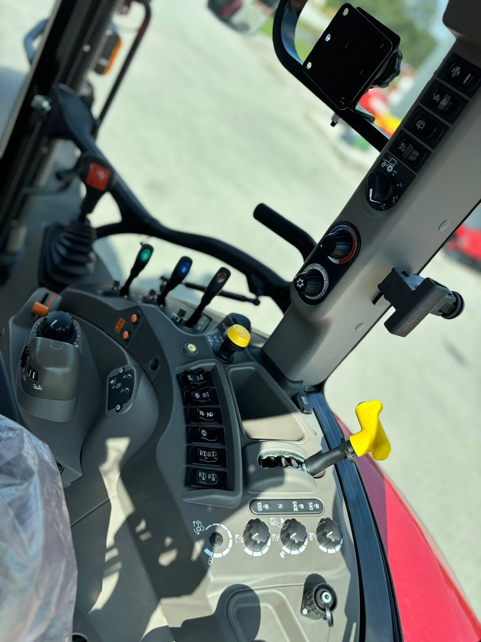 Wnętrze kabiny ciągnika CASE IH FARMALL 120M z konsolą boczną i dźwigniami sterowania